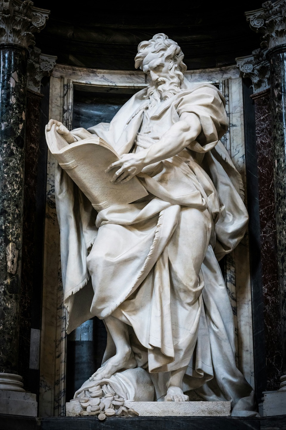 Marble statue of a bearded man holding an open book